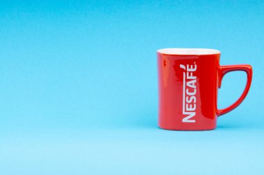 Kuala Lumpur, Malezya - 03 Temmuz 2019: Mavi arka plan üzerine promosyon kırmızı Nescafe kupa. Seçici odaklama