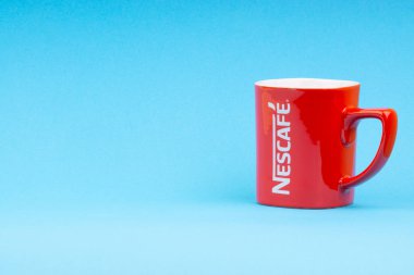 Kuala Lumpur, Malezya - 03 Temmuz 2019: Mavi arka plan üzerine promosyon kırmızı Nescafe kupa. Seçici odaklama