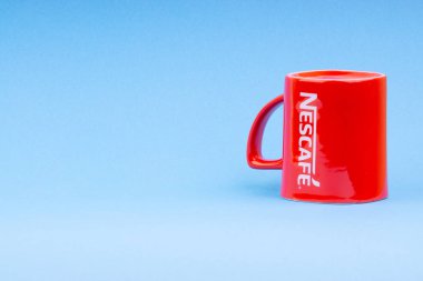 Kuala Lumpur, Malezya - 03 Temmuz 2019: Mavi arka plan üzerine promosyon kırmızı Nescafe kupa. Seçici odaklama
