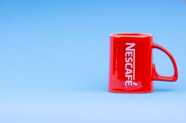 Kuala Lumpur, Malezya - 03 Temmuz 2019: Mavi arka plan üzerine promosyon kırmızı Nescafe kupa. Seçici odaklama