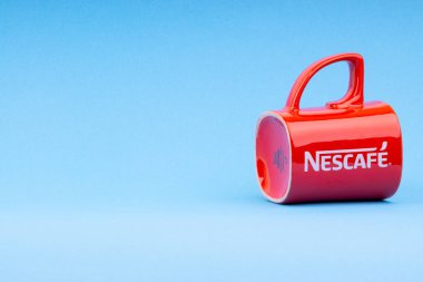 Kuala Lumpur, Malezya - 03 Temmuz 2019: Mavi arka plan üzerine promosyon kırmızı Nescafe kupa. Seçici odaklama
