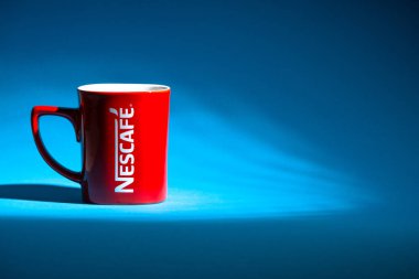 Kuala Lumpur, Malezya - 03 Temmuz 2019: Mavi arka plan üzerine promosyon kırmızı Nescafe kupa. Seçici odaklama