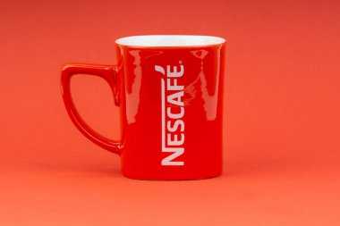 Kuala Lumpur, Malezya - 24 Haziran 2019: Kırmızı Nescafe kupa kırmızı arka plan üzerinde izole. Seçici odaklama
