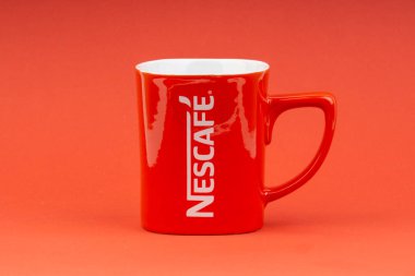 Kuala Lumpur, Malezya - 24 Haziran 2019: Kırmızı Nescafe kupa kırmızı arka plan üzerinde izole. Seçici odaklama