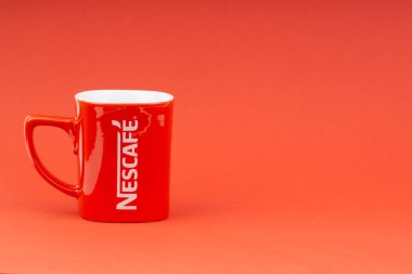 Kuala Lumpur, Malezya - 24 Haziran 2019: Kırmızı Nescafe kupa kırmızı arka plan üzerinde izole. Seçici odaklama