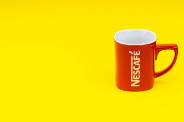 Kuala Lumpur, Malezya - 24 Haziran 2019: Kırmızı Nescafe kupa sarı arka plan üzerinde izole. Seçici odaklama