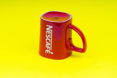 Kuala Lumpur, Malezya - 24 Haziran 2019: Kırmızı Nescafe kupa sarı arka plan üzerinde izole. Seçici odaklama