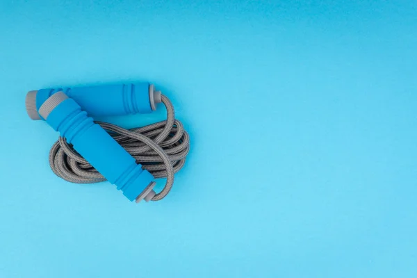青い背景に隔離されたロープやジャンプロープをスキップします 選択的なフォーカスと作物の断片 — ストック写真