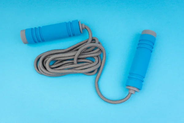 Skipping rope or jumping rope isolated on blue background. Selective focus and crop fragment