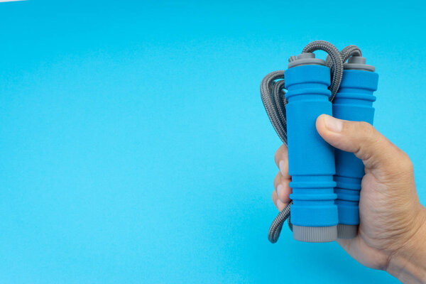 Skipping rope or jumping rope isolated on blue background. Selective focus and crop fragment