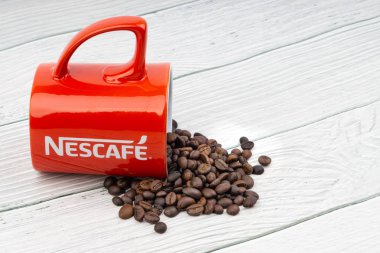 Kuala Lumpur, Malezya - 03 Temmuz 2019: Ahşap arka planda promosyon kırmızı Nescafe kupa. Seçici odaklama