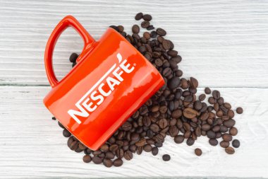 Kuala Lumpur, Malezya - 03 Temmuz 2019: Ahşap arka planda promosyon kırmızı Nescafe kupa. Seçici odaklama