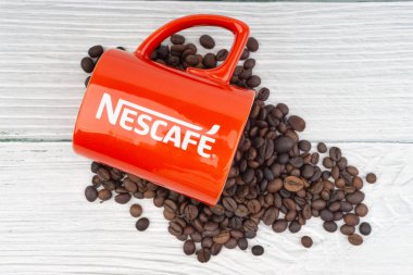 Kuala Lumpur, Malezya - 03 Temmuz 2019: Ahşap arka planda promosyon kırmızı Nescafe kupa. Seçici odaklama