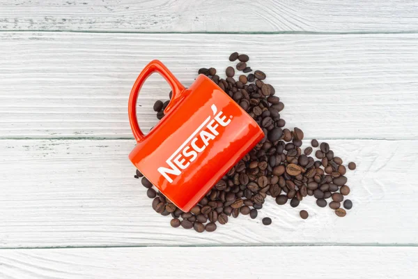 Kuala Lumpur, Malezya - 03 Temmuz 2019: Ahşap arka planda promosyon kırmızı Nescafe kupa. Seçici odaklama
