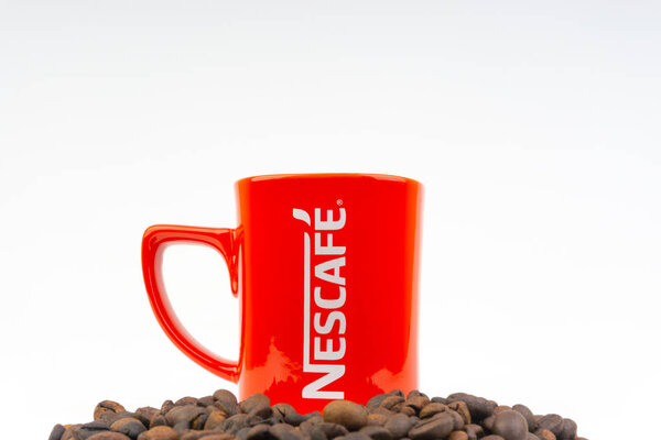 Kuala Lumpur, Malaysia - July 03, 2019:  Promotional red Nescafe mug on white background. Selective focus