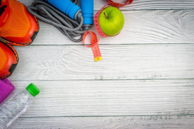 Üst veya düz havlu, su, elma meyve, spor ayakkabı ve ahşap arka plan üzerinde kopya alanı ile ip atlama görünümü yatıyordu. Sağlıklı bir kavram. Seçici odaklama.