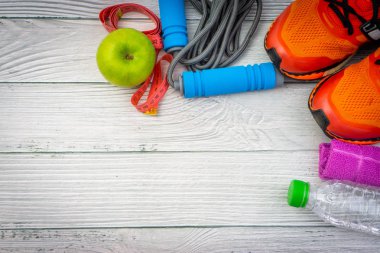 Üst veya düz havlu, su, elma meyve, spor ayakkabı ve ahşap arka plan üzerinde kopya alanı ile ip atlama görünümü yatıyordu. Sağlıklı bir kavram. Seçici odaklama.