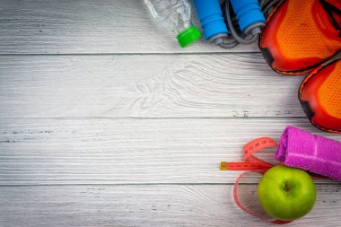 Üst veya düz havlu, su, elma meyve, spor ayakkabı ve ahşap arka plan üzerinde kopya alanı ile ip atlama görünümü yatıyordu. Sağlıklı bir kavram. Seçici odaklama.