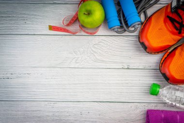 Üst veya düz havlu, su, elma meyve, spor ayakkabı ve ahşap arka plan üzerinde kopya alanı ile ip atlama görünümü yatıyordu. Sağlıklı bir kavram. Seçici odaklama.