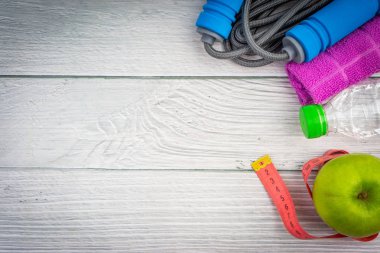 Üst veya düz havlu, su, elma meyve ve ahşap arka plan üzerinde kopya alanı alanı ile ip atlama görünümü yatıyordu. Sağlıklı bir kavram. Seçici odaklama.