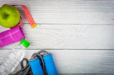 Üst veya düz havlu, su, elma meyve ve ahşap arka plan üzerinde kopya alanı alanı ile ip atlama görünümü yatıyordu. Sağlıklı bir kavram. Seçici odaklama.