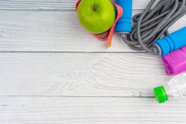 Üst veya düz havlu, su, elma meyve ve ahşap arka plan üzerinde kopya alanı alanı ile ip atlama görünümü yatıyordu. Sağlıklı bir kavram. Seçici odaklama.