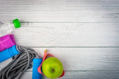 Üst veya düz havlu, su, elma meyve ve ahşap arka plan üzerinde kopya alanı alanı ile ip atlama görünümü yatıyordu. Sağlıklı bir kavram. Seçici odaklama.