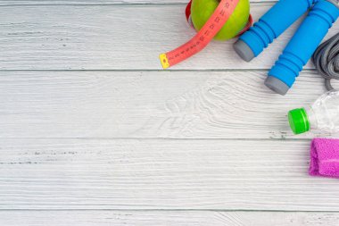 Üst veya düz havlu, su, elma meyve ve ahşap arka plan üzerinde kopya alanı alanı ile ip atlama görünümü yatıyordu. Sağlıklı bir kavram. Seçici odaklama.