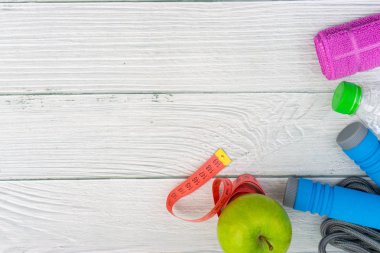 Üst veya düz havlu, su, elma meyve ve ahşap arka plan üzerinde kopya alanı alanı ile ip atlama görünümü yatıyordu. Sağlıklı bir kavram. Seçici odaklama.