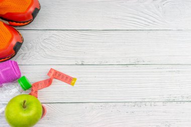 Ahşap arka plan üzerinde kopya alanı ile havlu, su, elma meyve ve spor ayakkabı üst veya düz yatıyordu görünümü. Sağlıklı bir kavram. Seçici odaklama.