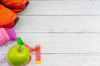 Ahşap arka plan üzerinde kopya alanı ile havlu, su, elma meyve ve spor ayakkabı üst veya düz yatıyordu görünümü. Sağlıklı bir kavram. Seçici odaklama.