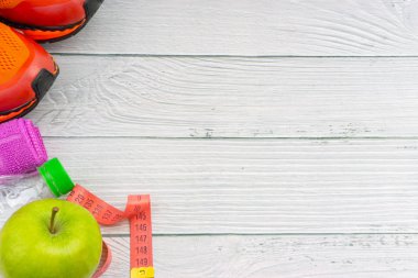 Ahşap arka plan üzerinde kopya alanı ile havlu, su, elma meyve ve spor ayakkabı üst veya düz yatıyordu görünümü. Sağlıklı bir kavram. Seçici odaklama.