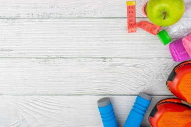 Üst veya düz havlu, su, elma meyve, ahşap arka plan üzerinde kopya alanı ile ip ve spor ayakkabı atlama görünümü yatıyordu. Sağlıklı bir kavram. Seçici odaklama.