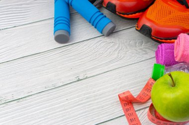 Üst veya düz havlu, su, elma meyve, spor ayakkabı ve ahşap arka plan üzerinde kopya alanı ile ip atlama görünümü yatıyordu. Sağlıklı bir kavram. Seçici odaklama.