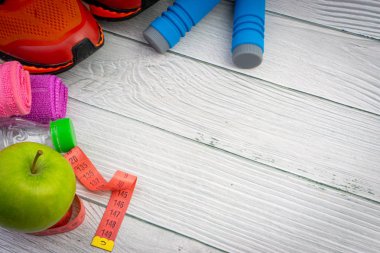 Üst veya düz havlu, su, elma meyve, spor ayakkabı ve ahşap arka plan üzerinde kopya alanı ile ip atlama görünümü yatıyordu. Sağlıklı bir kavram. Seçici odaklama.