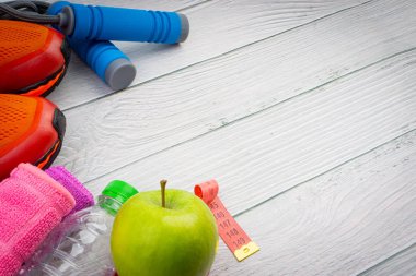 Üst veya düz havlu, su, elma meyve, spor ayakkabı ve ahşap arka plan üzerinde kopya alanı ile ip atlama görünümü yatıyordu. Sağlıklı bir kavram. Seçici odaklama.