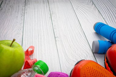 Üst veya düz havlu, su, elma meyve, spor ayakkabı ve ahşap arka plan üzerinde kopya alanı ile ip atlama görünümü yatıyordu. Sağlıklı bir kavram. Seçici odaklama.