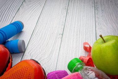 Üst veya düz havlu, su, elma meyve, spor ayakkabı ve ahşap arka plan üzerinde kopya alanı ile ip atlama görünümü yatıyordu. Sağlıklı bir kavram. Seçici odaklama.