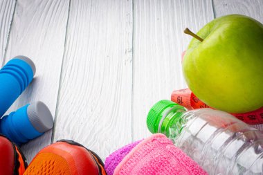 Üst veya düz havlu, su, elma meyve, spor ayakkabı ve ahşap arka plan üzerinde kopya alanı ile ip atlama görünümü yatıyordu. Sağlıklı bir kavram. Seçici odaklama.
