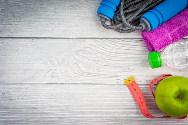 Üst veya düz havlu, su, elma meyve ve ahşap arka plan üzerinde kopya alanı alanı ile ip atlama görünümü yatıyordu. Sağlıklı bir kavram. Seçici odaklama.