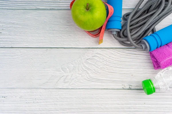 Üst veya düz havlu, su, elma meyve ve ahşap arka plan üzerinde kopya alanı alanı ile ip atlama görünümü yatıyordu. Sağlıklı bir kavram. Seçici odaklama.