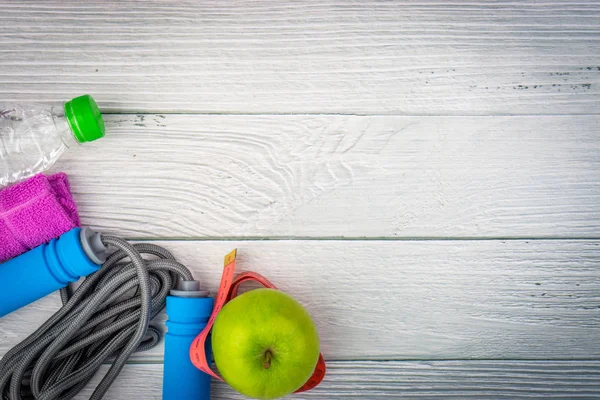 Üst veya düz havlu, su, elma meyve ve ahşap arka plan üzerinde kopya alanı alanı ile ip atlama görünümü yatıyordu. Sağlıklı bir kavram. Seçici odaklama.