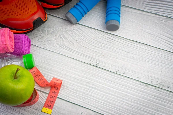 Üst veya düz havlu, su, elma meyve, spor ayakkabı ve ahşap arka plan üzerinde kopya alanı ile ip atlama görünümü yatıyordu. Sağlıklı bir kavram. Seçici odaklama.