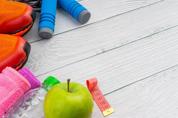 Üst veya düz havlu, su, elma meyve, spor ayakkabı ve ahşap arka plan üzerinde kopya alanı ile ip atlama görünümü yatıyordu. Sağlıklı bir kavram. Seçici odaklama.