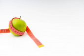 Zelený jablko s červenou měřicí páskou. Selektivní zaměření