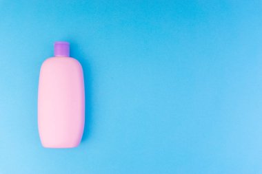 Mavi bir arka plan üzerinde bebek bakım ürünleri Düz yatıyordu kompozisyon. Şampuan veya duş şişesi jelyukarıdan görünüm