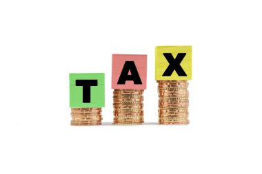 Yığılmış sikke ve beyaz arka plan üzerinde renkli ahşap blok ile Vergi Kavramı