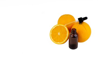 Beyaz arka planda damlalıklı ve turuncu olan C vitamini serum şişesi. Sağlık kavramı ve kopyalama alanı