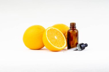 Beyaz arka planda damlalıklı ve turuncu olan C vitamini serum şişesi. Sağlık kavramı ve kopyalama alanı