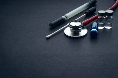 Tıbbi örnek, tüp ve steteskop siyah arka planda. Sağlık ve fotokopi alanı kavramı